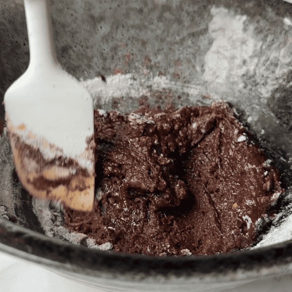 Folding chocolate chips and marshmallows into cookie batter
