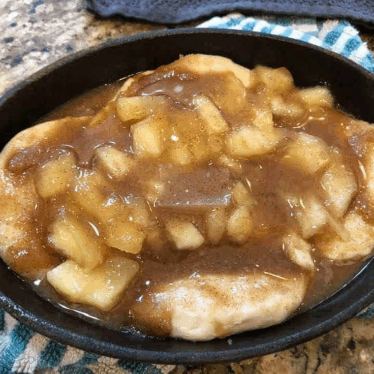 Remaining butter, cinnamon, and sugar mixture poured over apple-filled biscuits, ready to cook in air fryer at 320°F