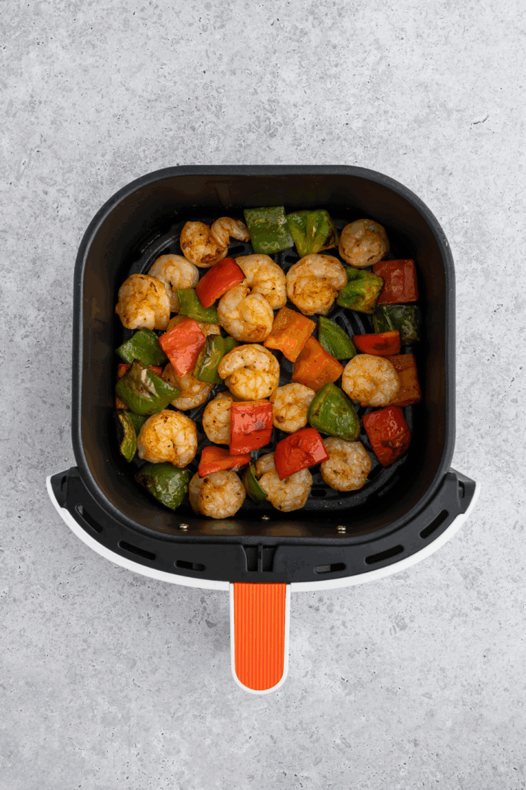 Air fryer sweet and sour shrimp plated over rice, drizzled with sauce