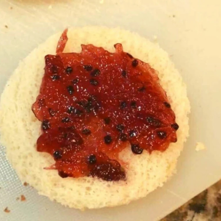 Spooning strawberry jam into the center of a bread circle