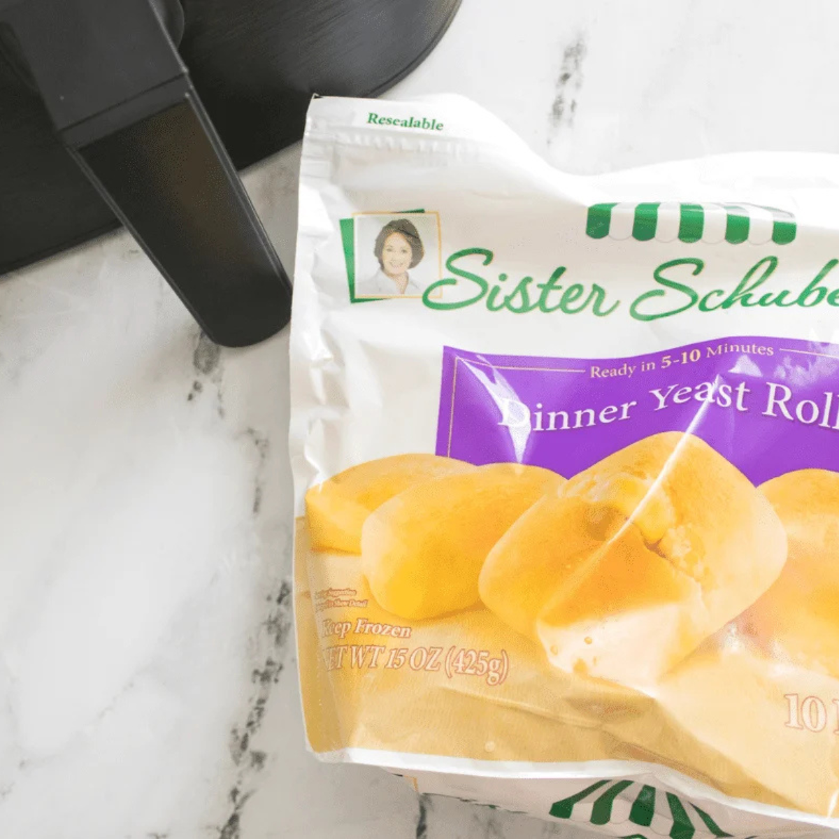 Frozen Sister Schubert's dinner rolls and a small bowl of melted butter on a countertop
