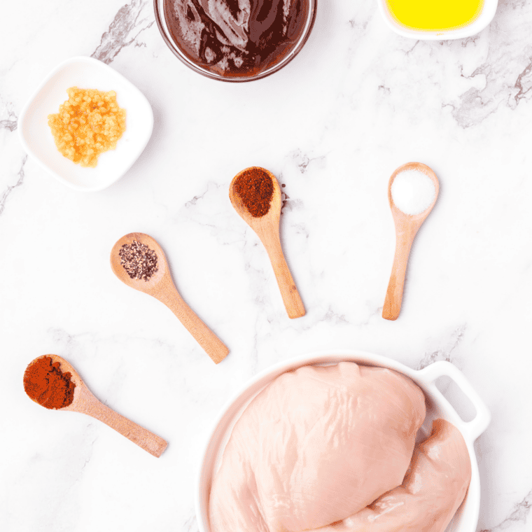 Ingredients for air fryer BBQ chicken breast: chicken breasts, BBQ sauce, and seasonings