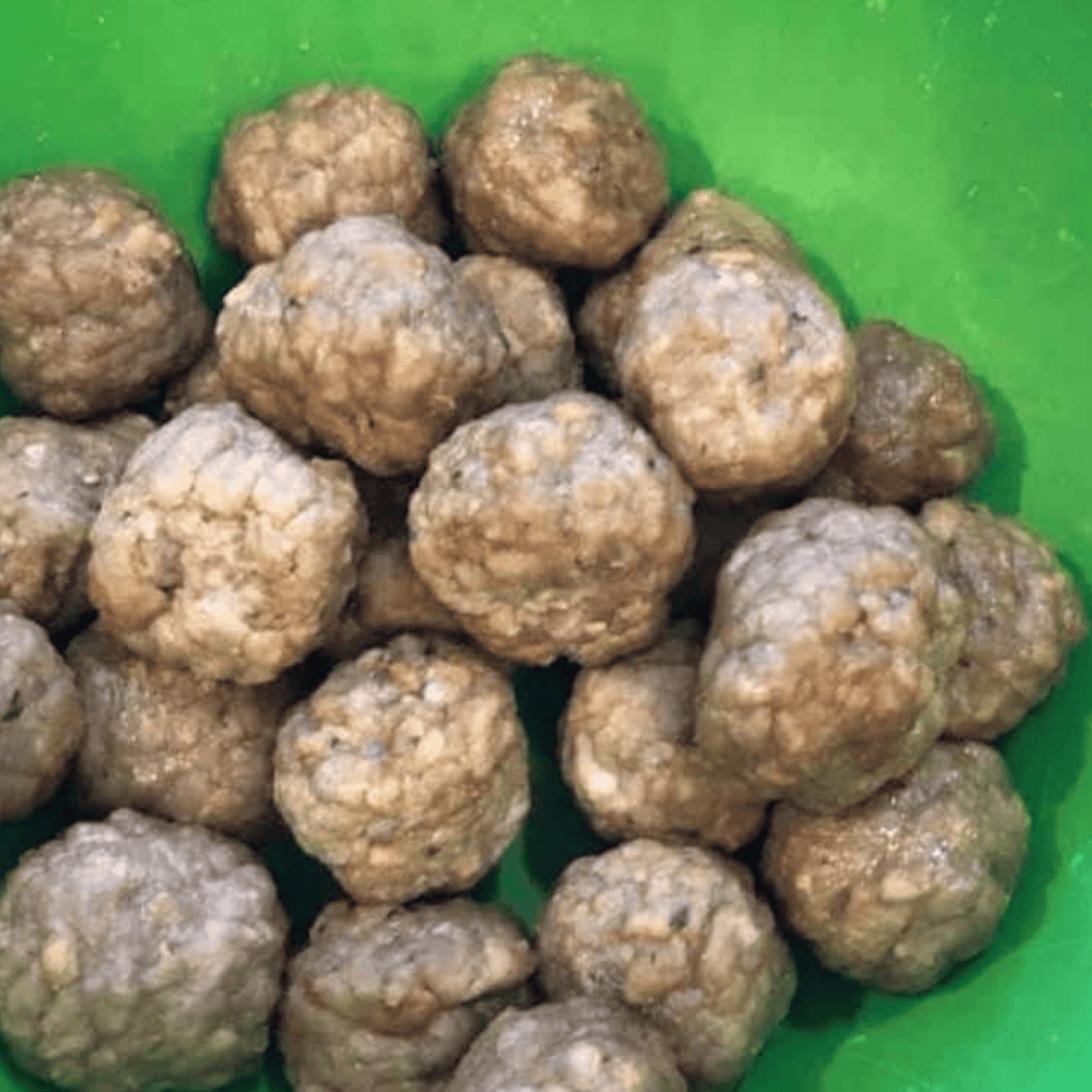 Thawed Italian meatballs in a bowl before assembling the air fryer biscuit bake