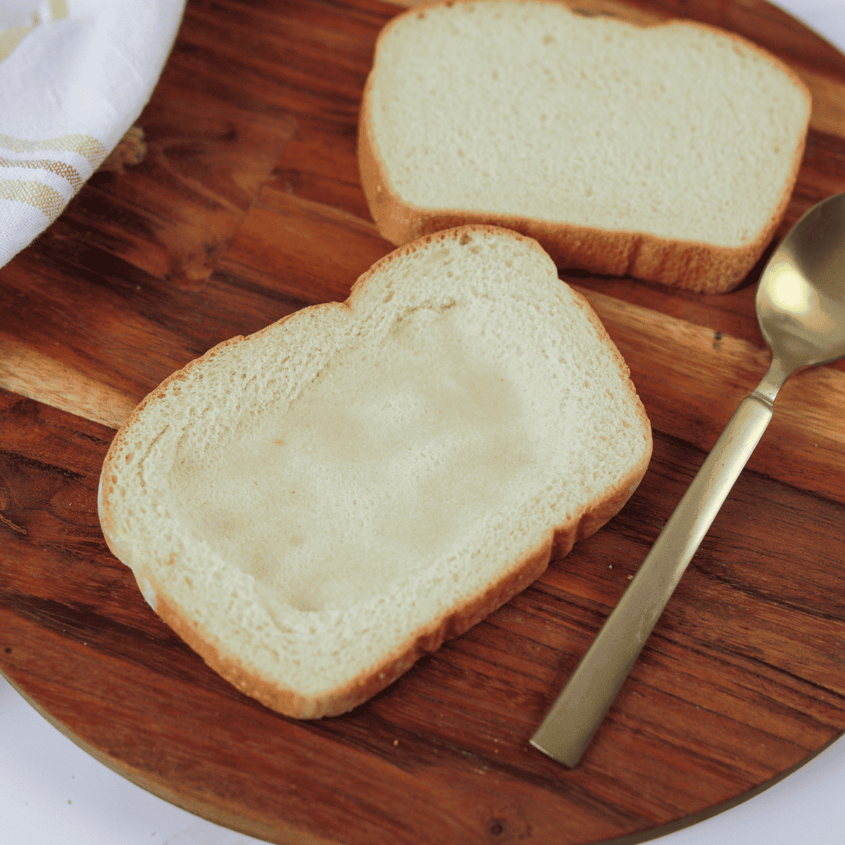 Using the back of a spoon to create a small indentation in the center of each bread slice.
