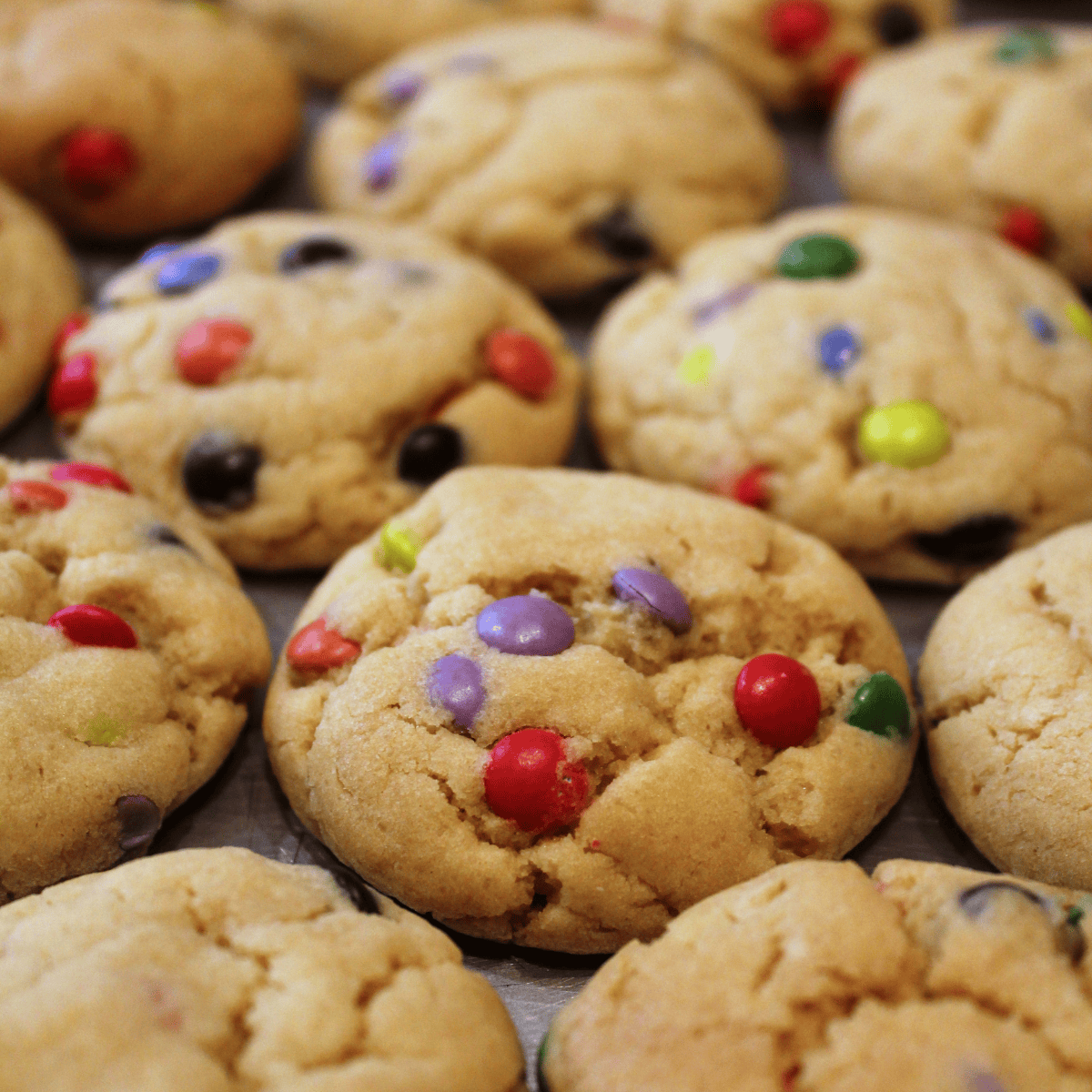 Air fryer M&M cookies with golden edges, soft centers, and colorful chocolate candies on top
