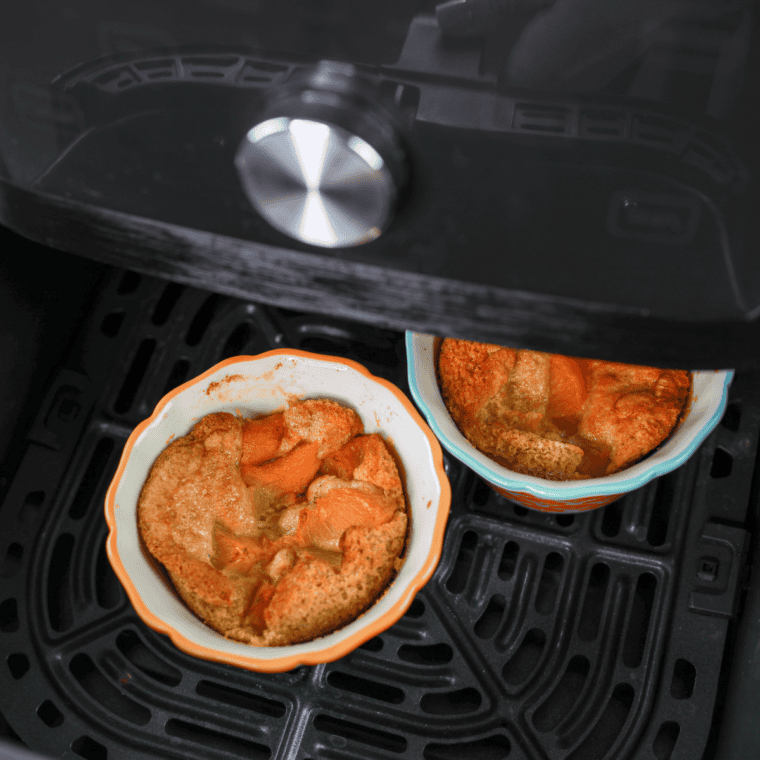Gluten-free peach cobbler baked in the air fryer with golden topping and bubbling peaches