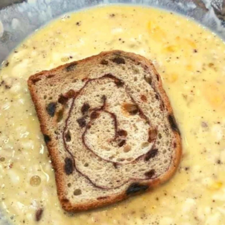 Dipping a slice of cinnamon raisin bread into the egg custard for 15 seconds per side