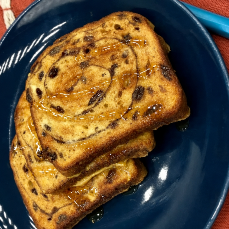 Air fryer cinnamon raisin french toast cut open to show the custardy center and visible raisins
