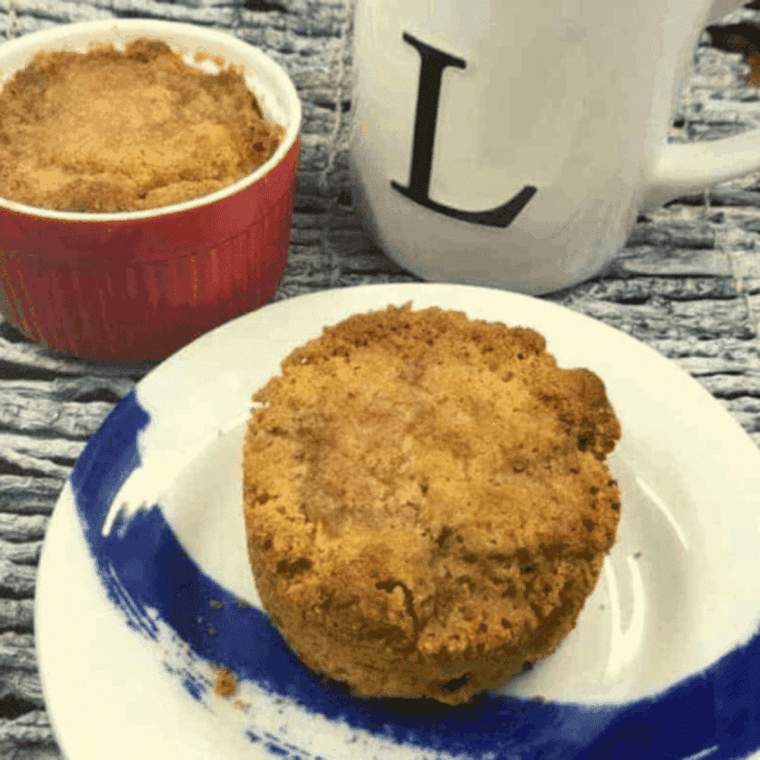 Two golden air fryer apple muffins with visible apple pieces and cinnamon