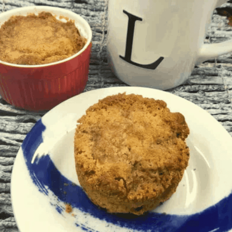 Two homemade apple muffins in the air fryer, golden brown, with cinnamon and diced apples.
