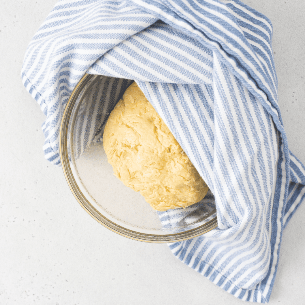 Dough resting in a lightly oiled bowl covered for rising.