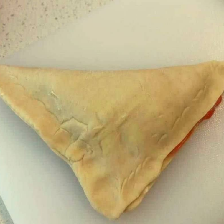 Folding puff pastry over blueberry filling and crimping edges with a fork.