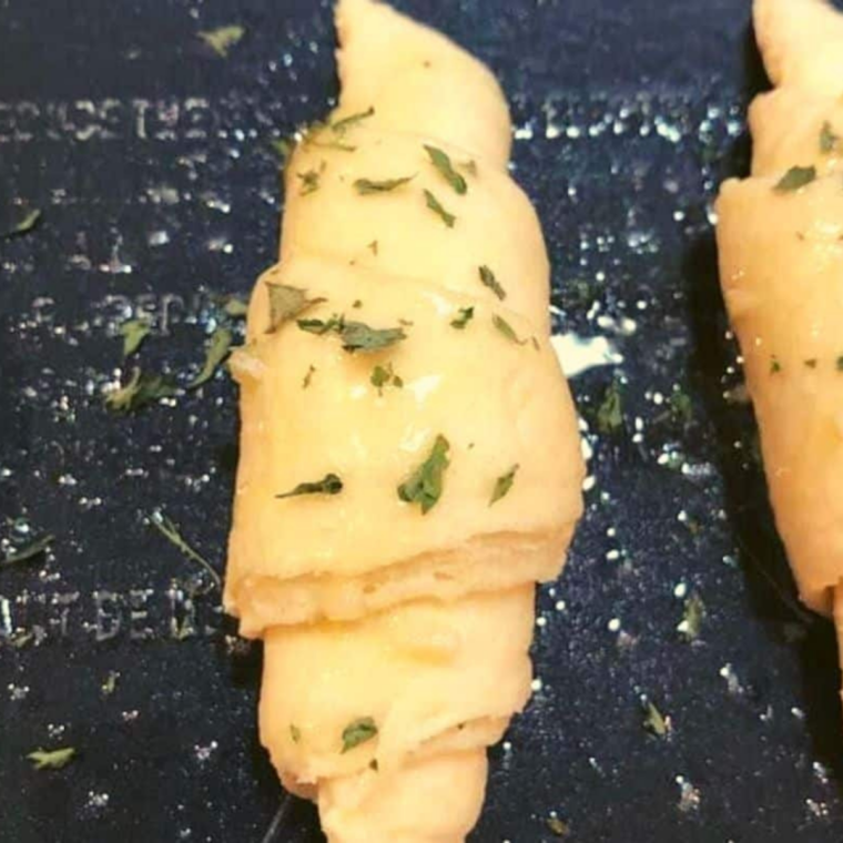 Crescent dough triangle brushed with garlic butter and rolled from the wide end
