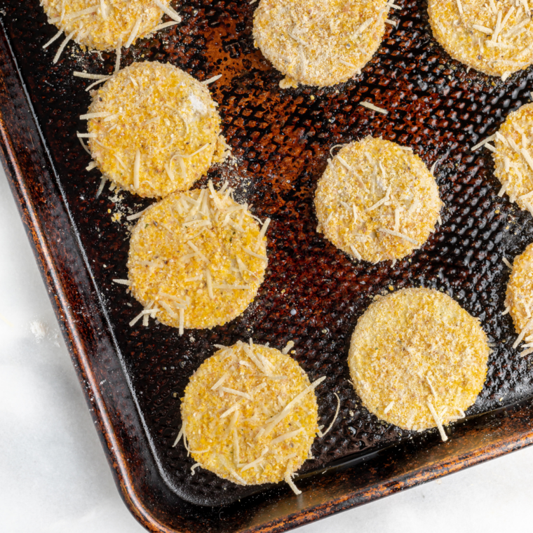 Crispy air fryer summer squash slices on a white plate garnished with fresh parsley