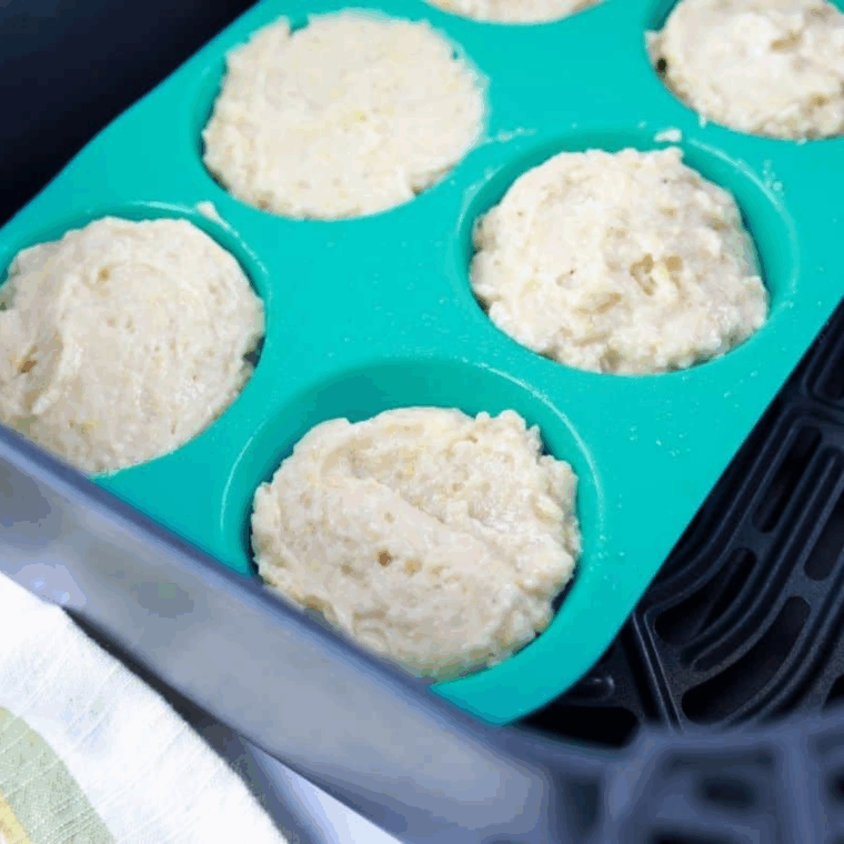 Air fryer banana chocolate chip muffin batter filled in greased or lined muffin tins, ready to bake