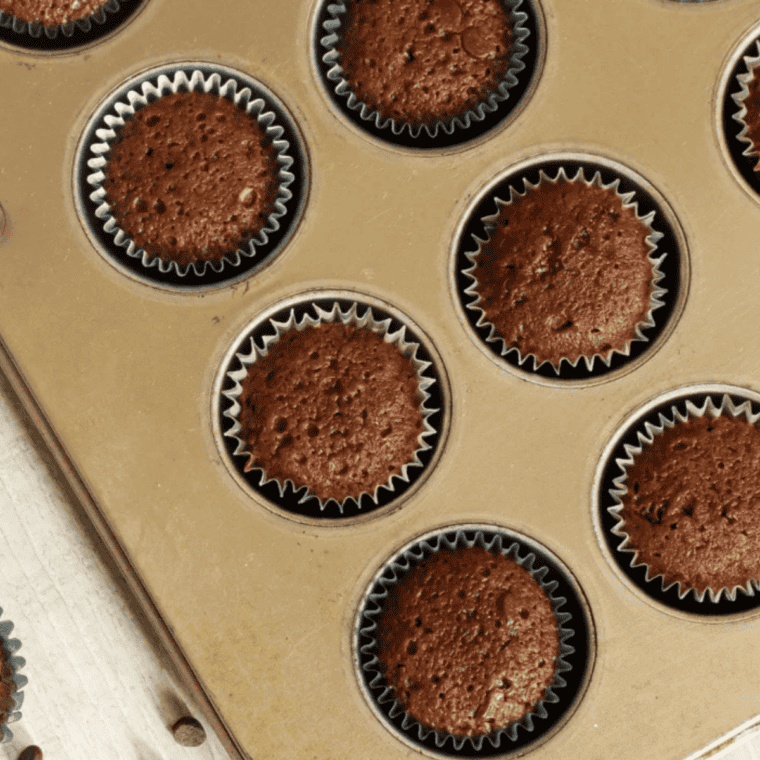 Air fryer brownie bites stacked on a white plate with fudgy centers showing