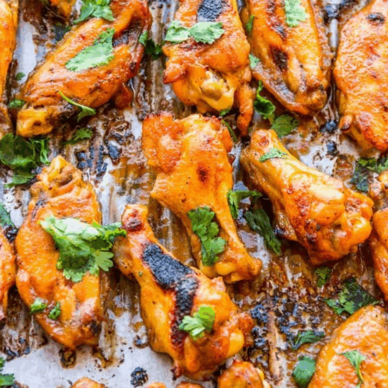 Crispy Air Fryer Chipotle-Lime Sticky Wings on a plate, glazed with smoky, sweet sauce and garnished with lime wedges.