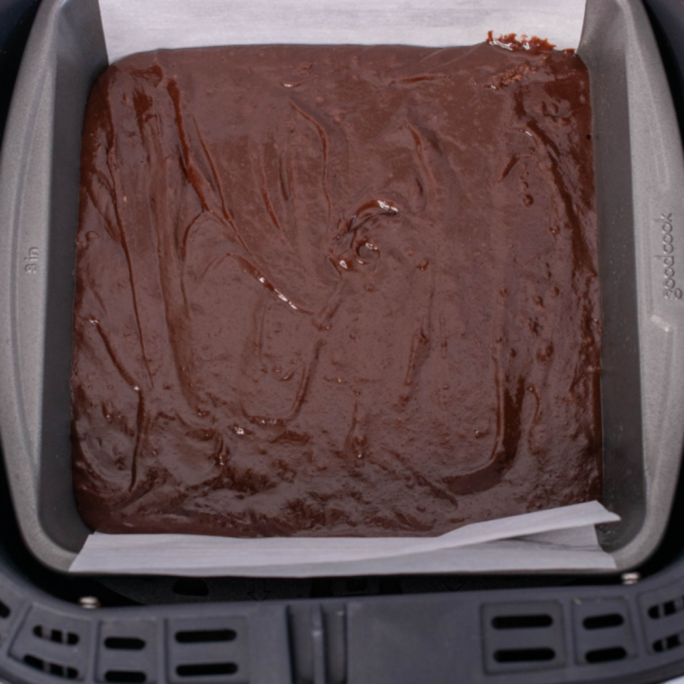 pouring brownie batter into pan and smoothing top before air frying until baked