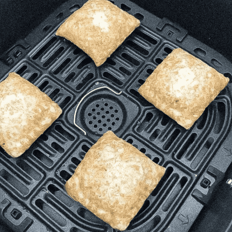 Four Entenmann's snack pies in an air fryer basket before cooking