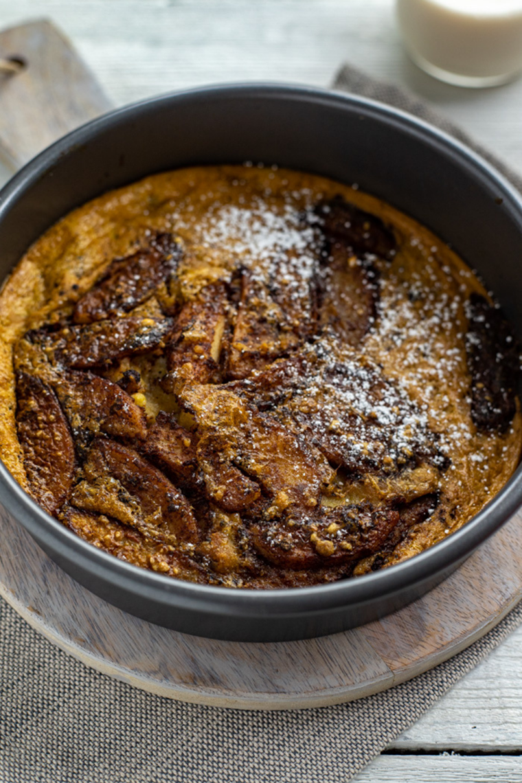 Air fryer apple pancake rising in pan with caramelized apples and crisp golden edges