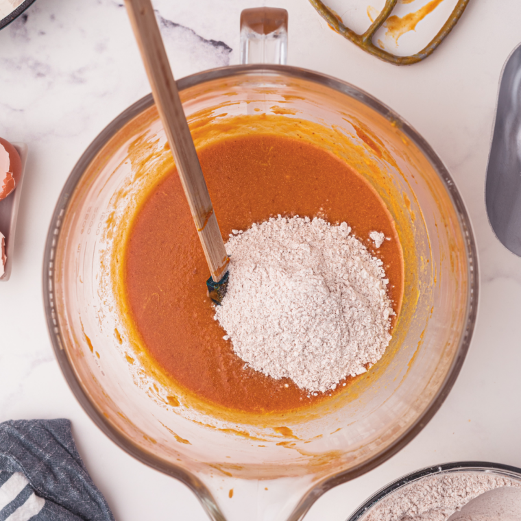 Flour, sugar, and spices whisked together in a large glass mixing bowl