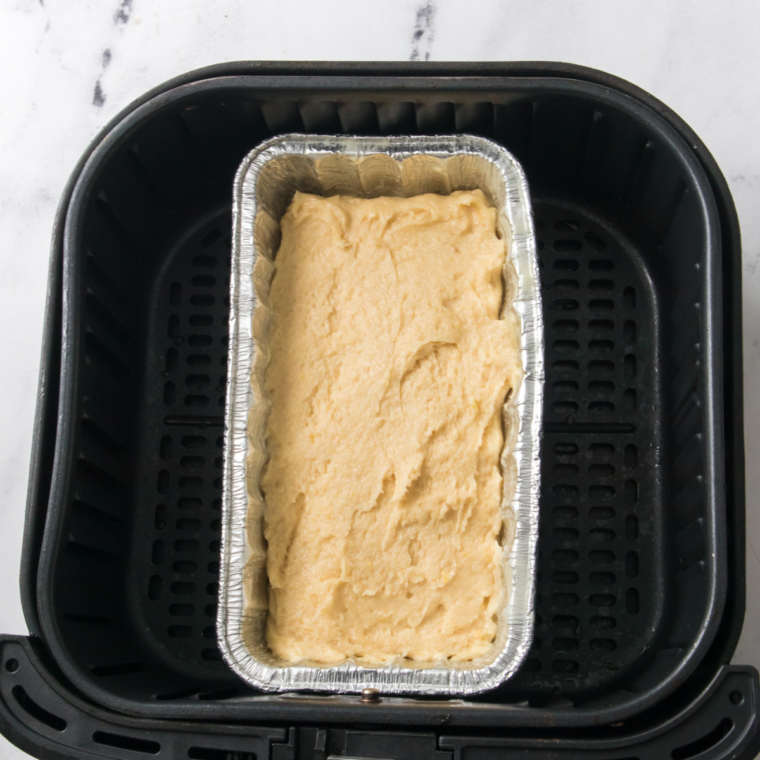 Raspberry quick bread batter poured two-thirds full into a greased mini loaf pan
