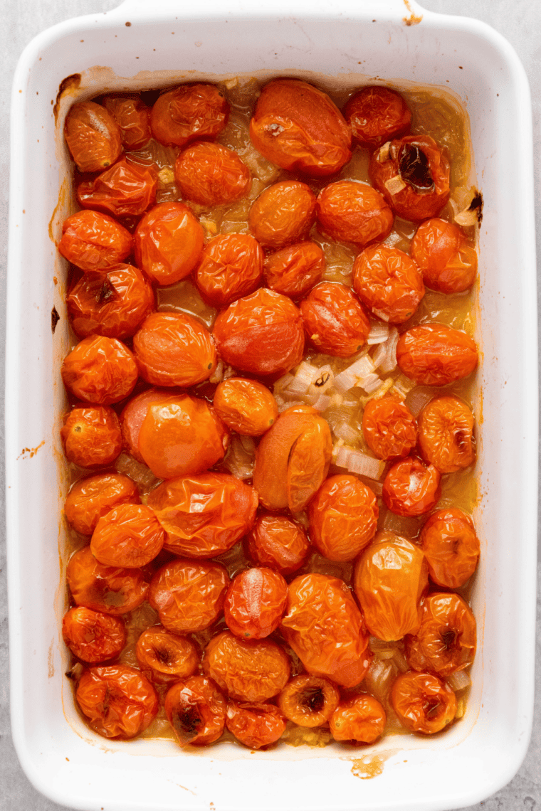 Roasted cherry tomatoes spooned into a serving bowl with the pan juices