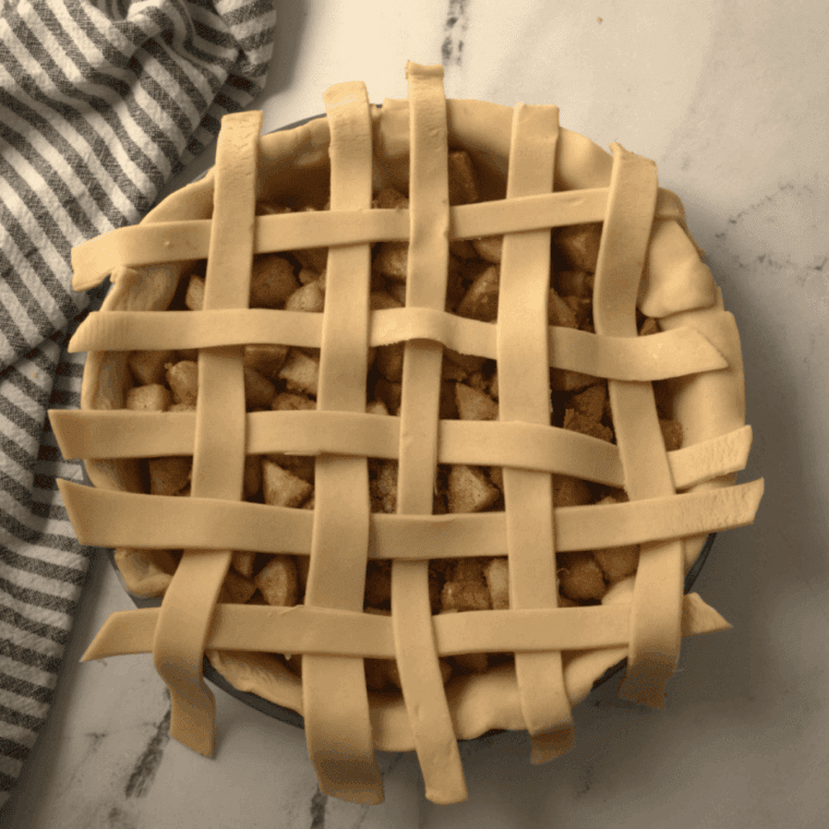 Assembled homemade apple pie on kitchen table.