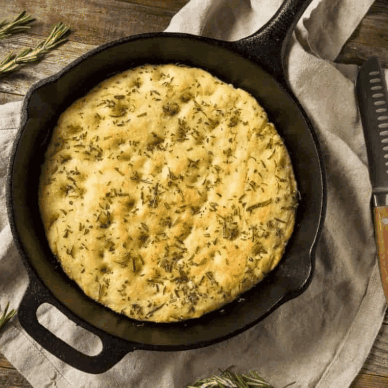 Air fryer garlic herb quick bread, golden crust, sliced, garnished with fresh herbs