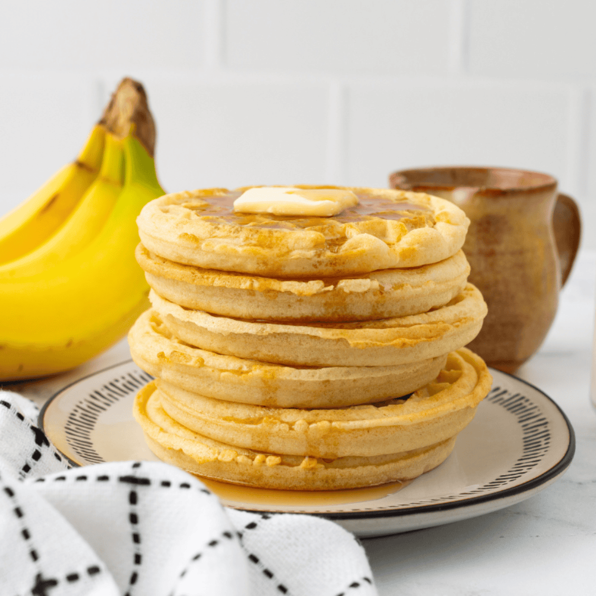 Golden frozen waffles crisping in an air fryer, ready to serve.