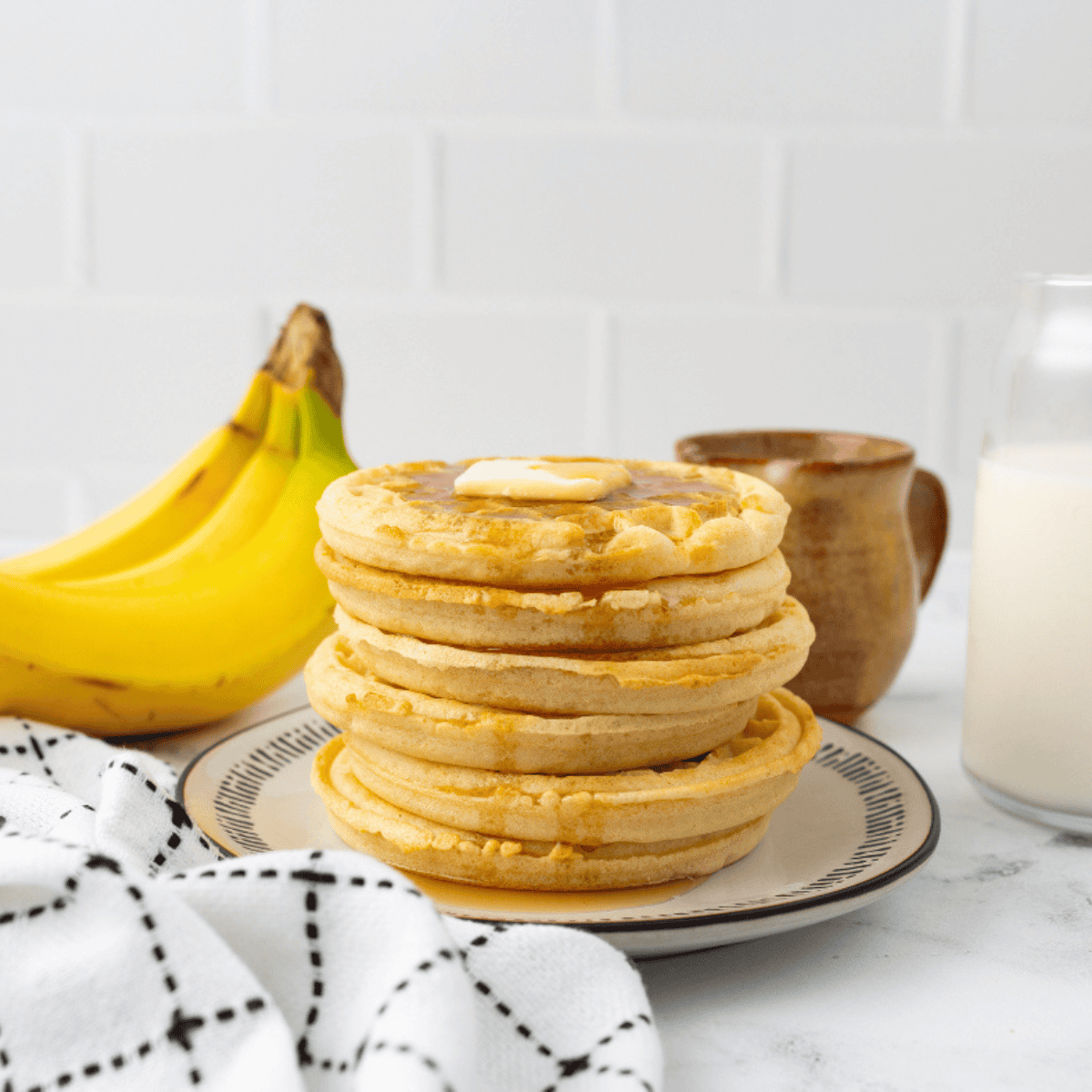 Frozen waffles cooking in an air fryer basket until golden and crispy.