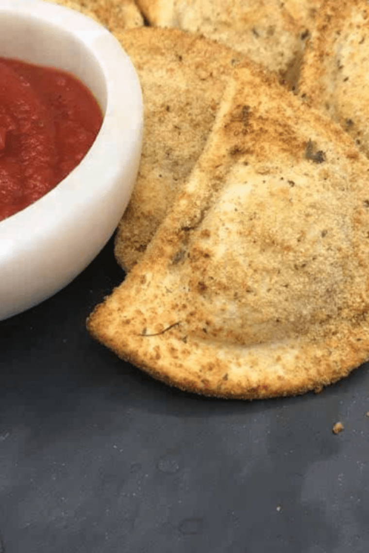Golden, crispy breaded pierogies cooking in an air fryer basket, ready to serve.