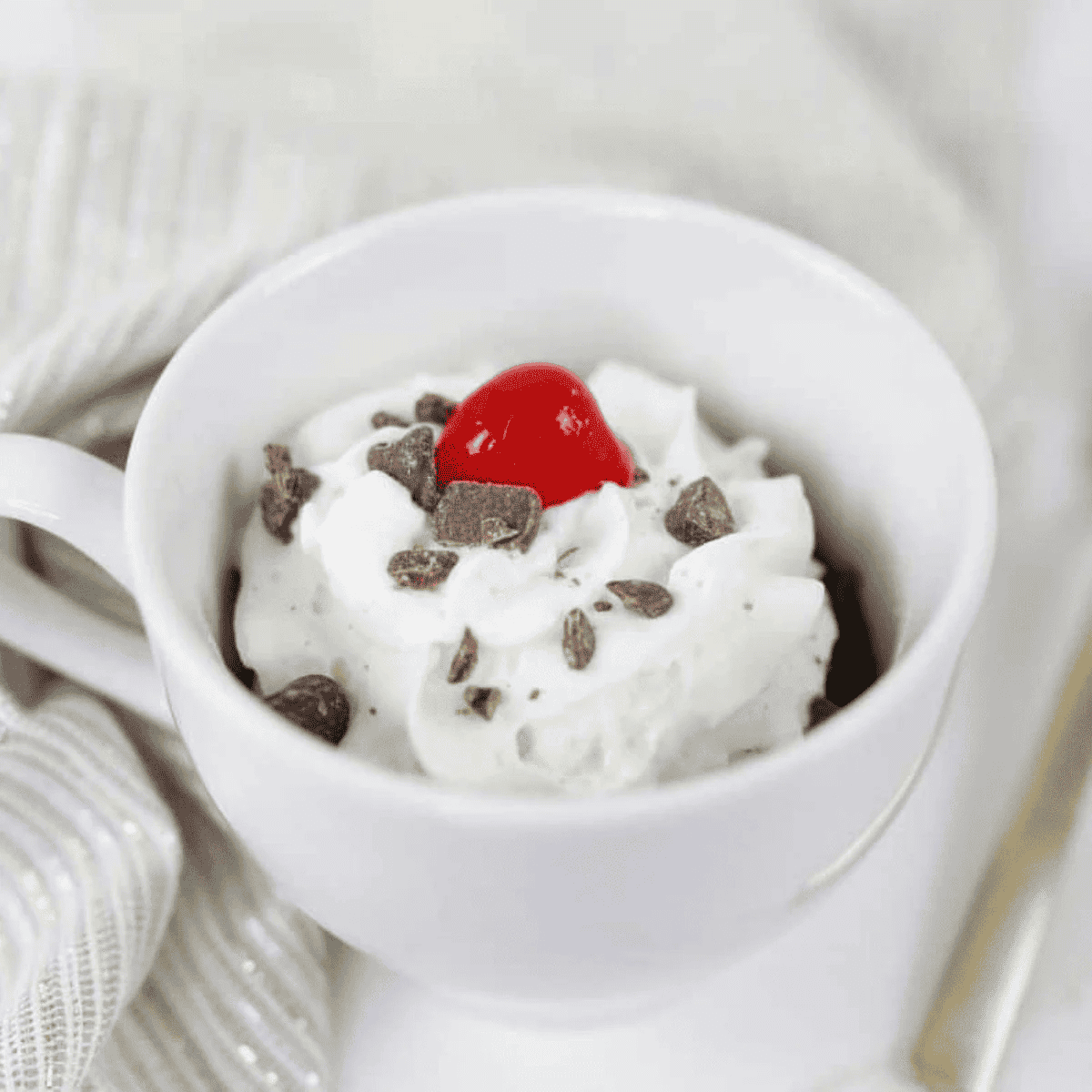 Warm fudgy brownie in a mug cooked in air fryer, rich chocolate single-serve dessert with gooey center served for quick treat or snack