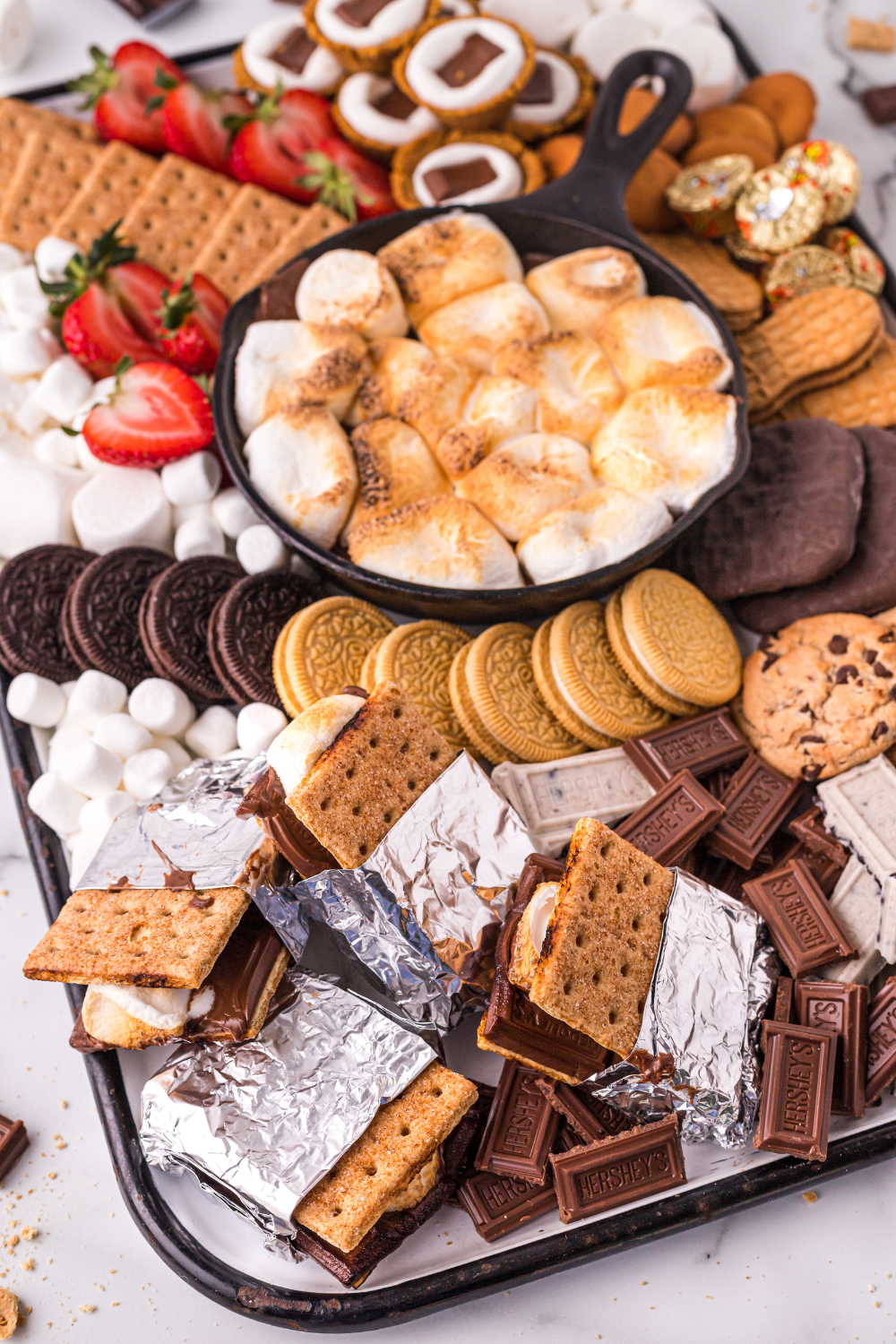air fryer s'mores dip topped with golden toasted marshmallows and graham crackers standing in the melted chocolate
