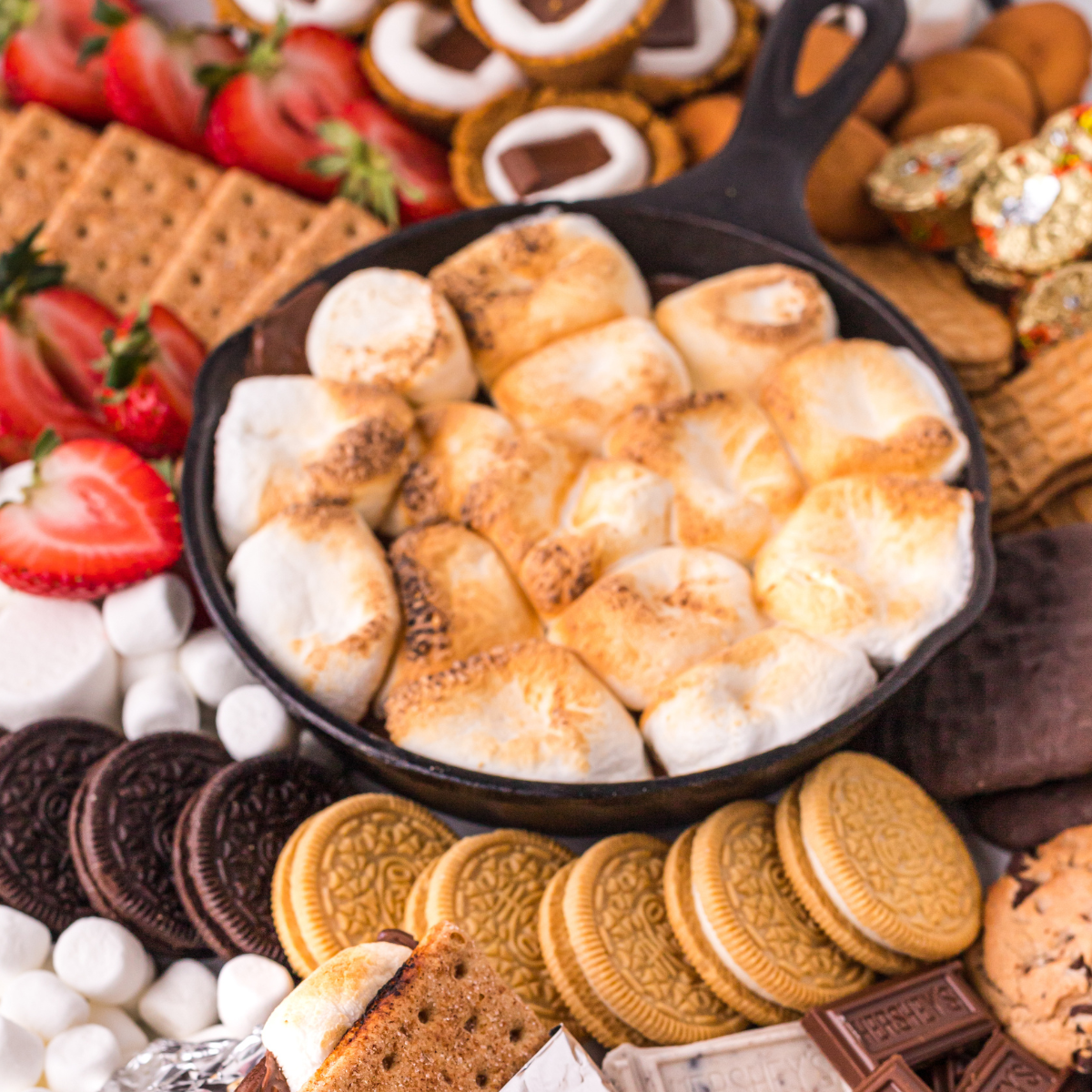 overhead closeup of air fryer s'mores dip with golden toasted marshmallows and melted chocolate in a cast iron skillet