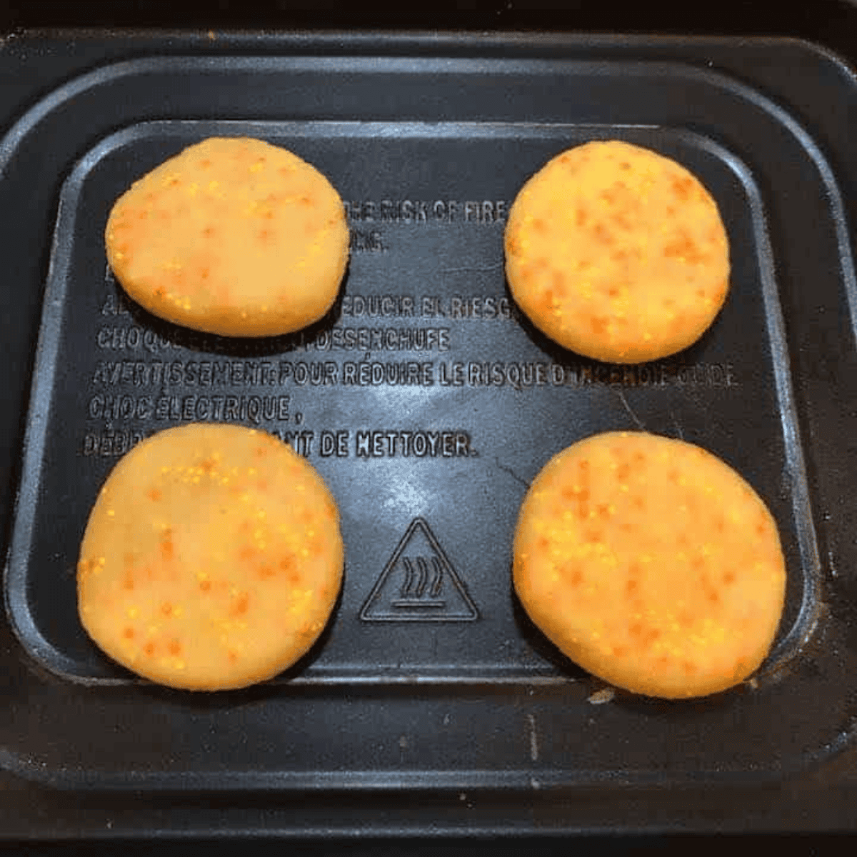 Shaping Italian butter cookie dough into one-inch balls on air fryer tray