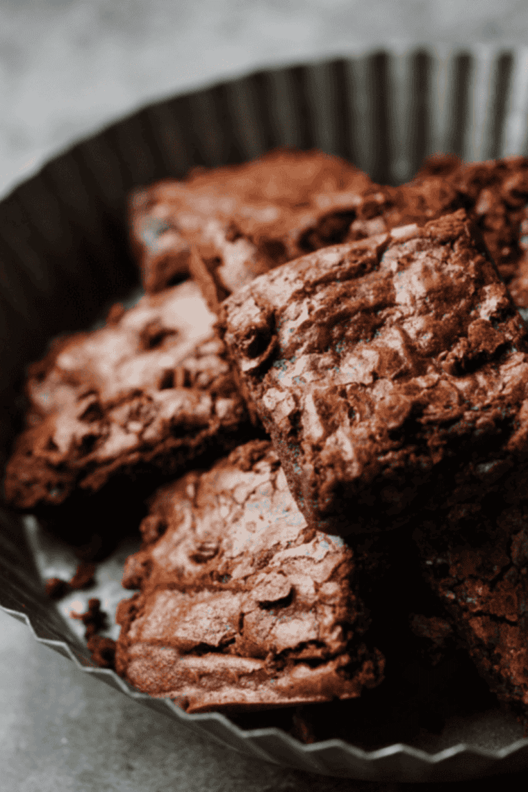 Small batch air fryer brownies cut into fudgy squares with crackly tops and gooey centers stacked on a cooling rack.