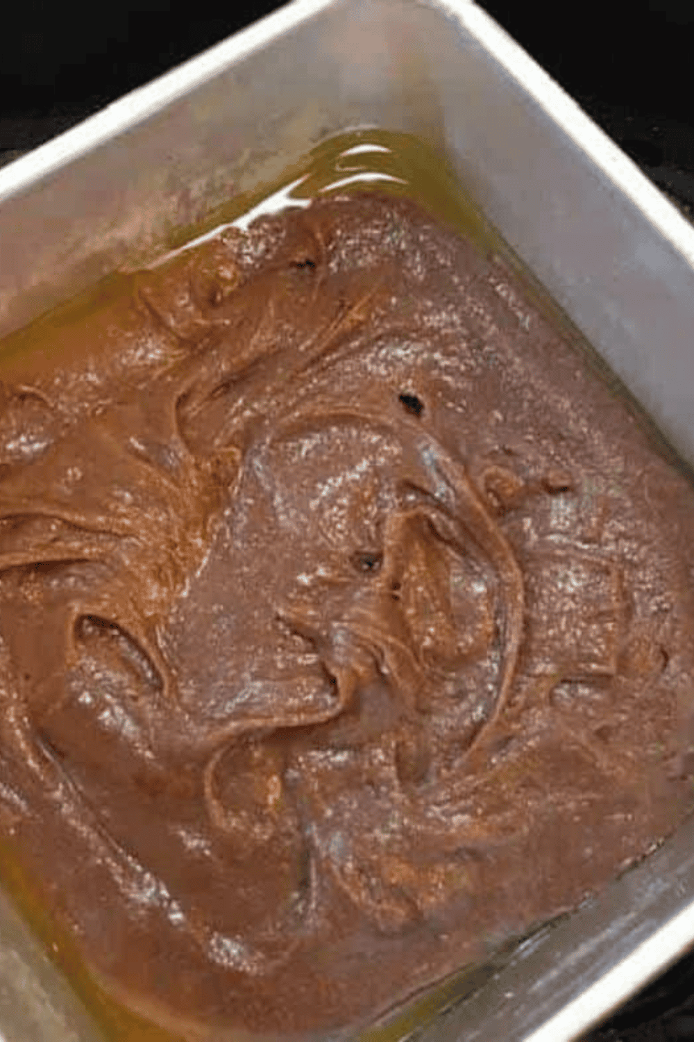 Mixing salt, vanilla extract, egg, and flour into brownie batter until smooth, then spraying pan with non-stick or olive oil spray before baking.