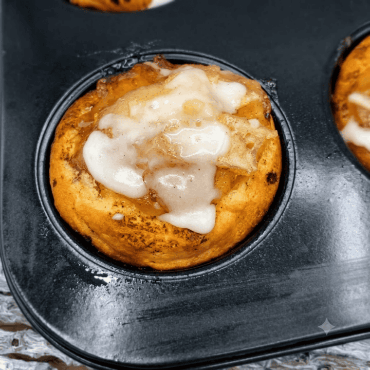 Air fryer apple pie cups drizzled with icing on a white plate
