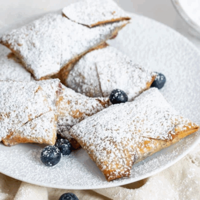 Plate of air fryer blueberry cheesecake egg rolls.