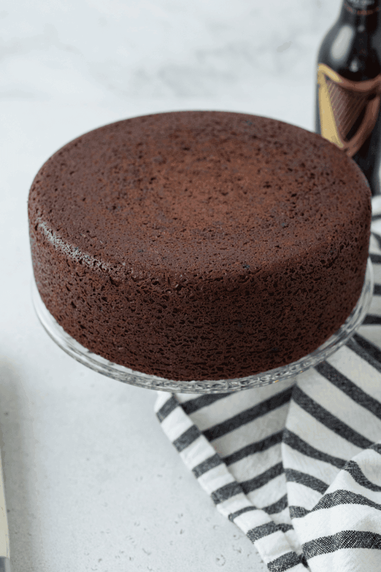 Spreading chocolate fudge frosting on a cooled one bowl chocolate cake 