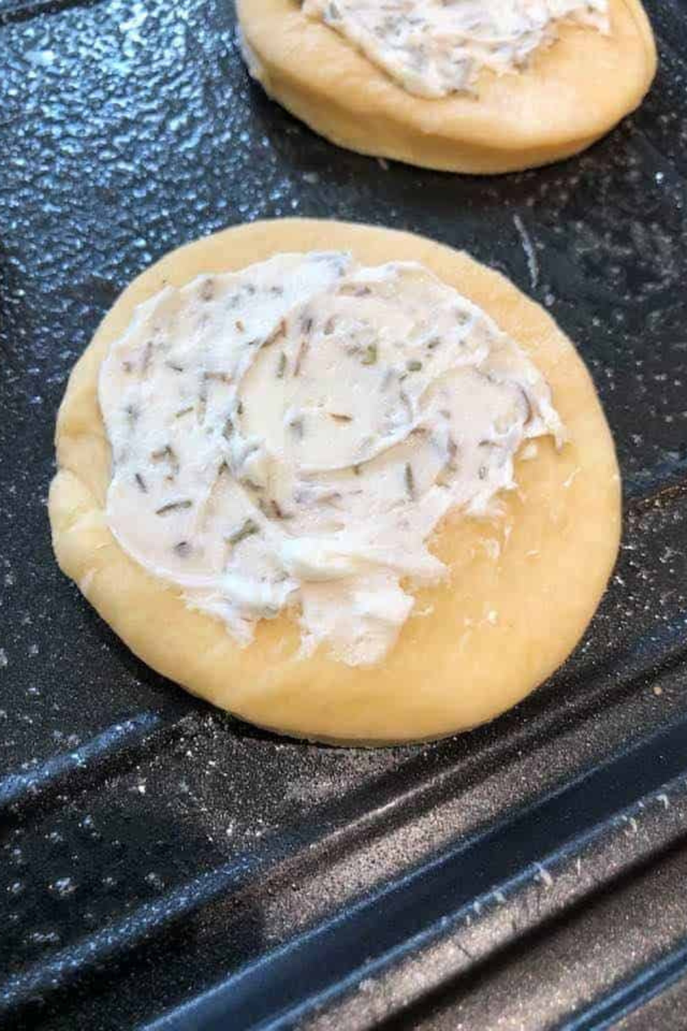 Unbaked goat cheese and tomato tarts assembled in air fryer basket with olive oil drizzle