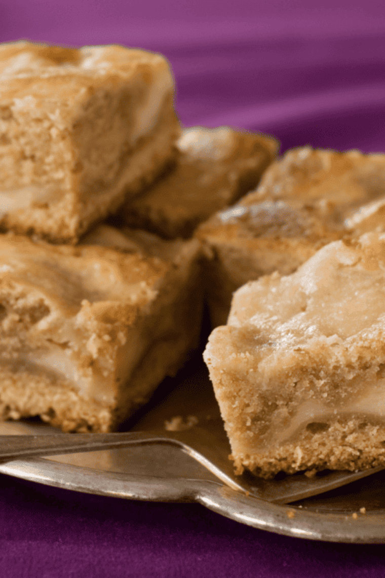 Air fryer blondies cut into squares with golden edges and soft chewy centers stacked on a cooling rack.