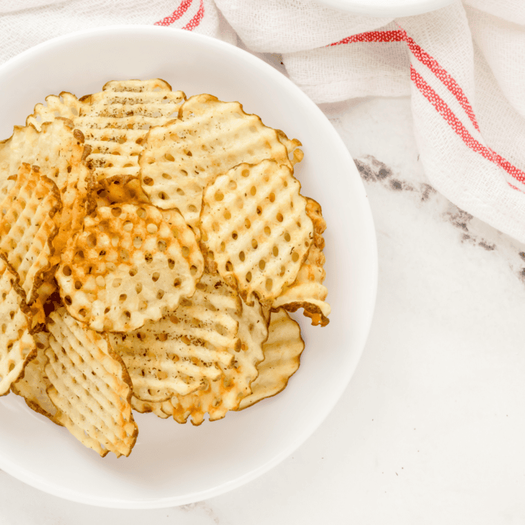Ingredients for air fryer loaded waffle fries including frozen waffle fries, shredded cheddar, bacon, sour cream, salsa, and jalapeños