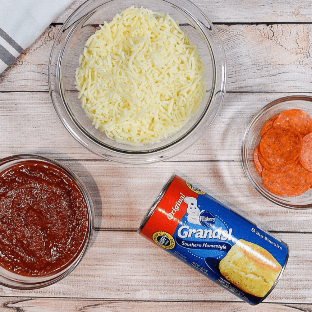 Ingredients needed for Air Fryer Pull Apart Pizza Bread on kitchen table.