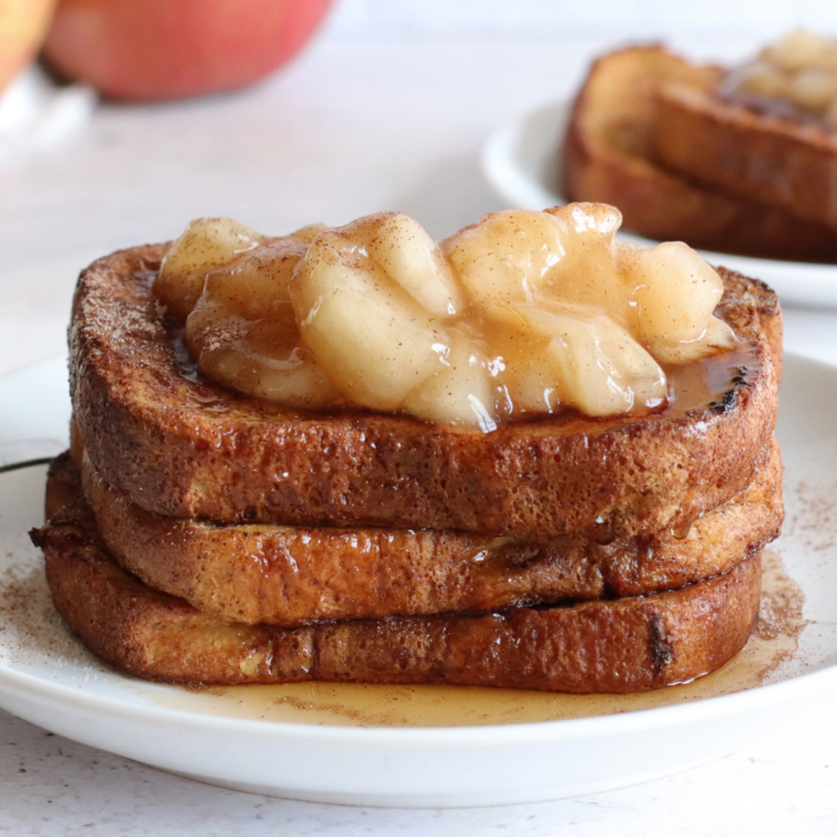Stack of air fryer pumpkin French toast slices topped with warm cinnamon apples and powdered sugar