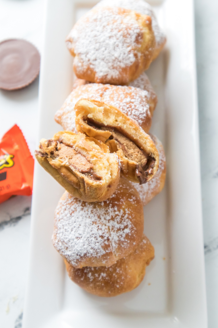 Air fryer peanut butter cup bombs wrapped in dough and cooked until golden brown with gooey melted Reese’s center for a quick sweet snack