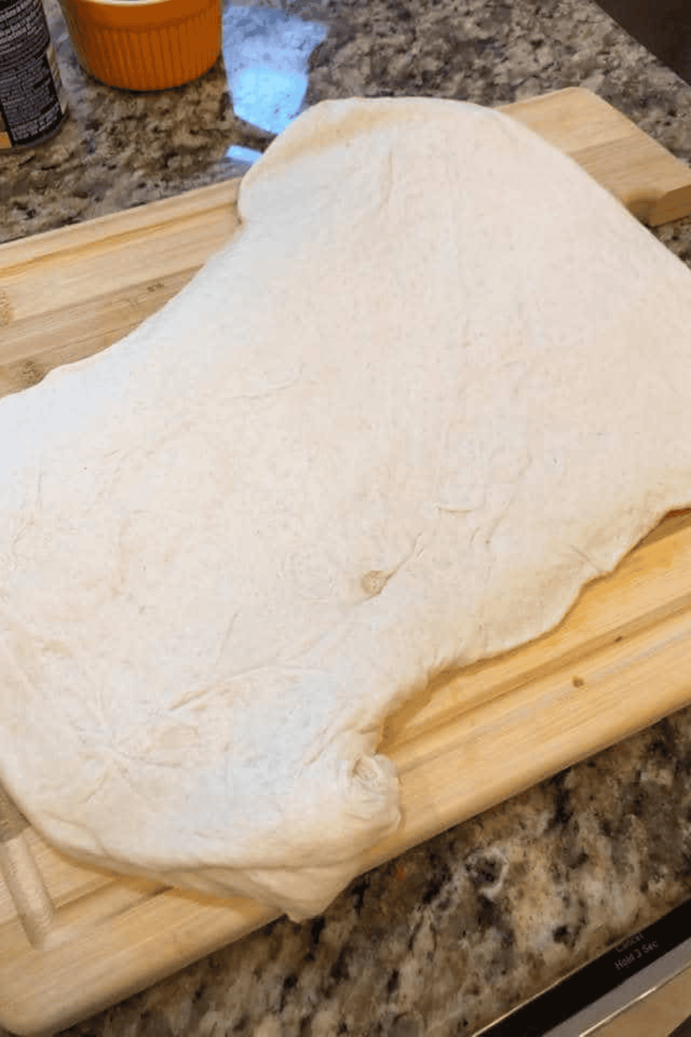 Pizza dough rolled out with spinach and feta in the center, edges pinched closed, and brushed with olive oil or melted butter.