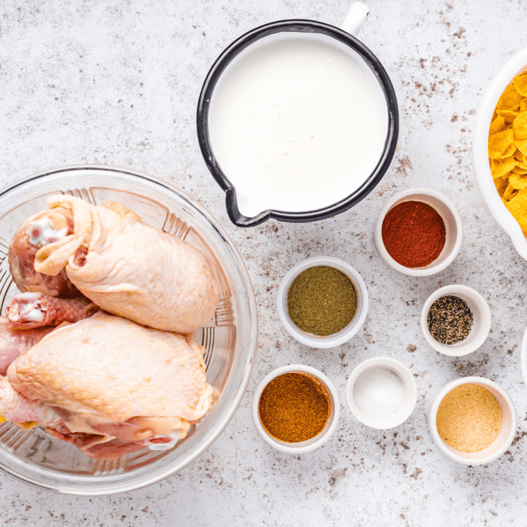 Ingredients for Captain Crunch Chicken laid out: Cap'n Crunch cereal, corn flakes, chicken tenders, flour, and eggs