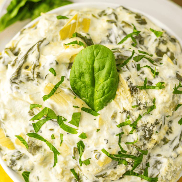Creamy Instant Pot copycat Olive Garden spinach artichoke dip in a white bowl, served with tortilla chips.